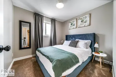 a bedroom with a large bed and a window at 5BD Jungle Oasis - HotTub - BBQ - King Bed - Games - Garage in Edmonton