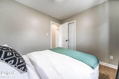a bedroom with a large white bed in a room at 5BD Jungle Oasis - HotTub - BBQ - King Bed - Games - Garage in Edmonton