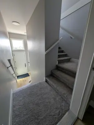 a hallway with stairs with a door and a window at Lakeview Hideaway in Victoria