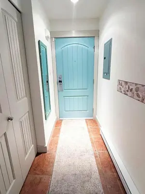 a hallway with a blue door and a tile floor at Oceanside Resort 3 BED 2 BATH with Indoor Pool and Hot Tub in Parksville