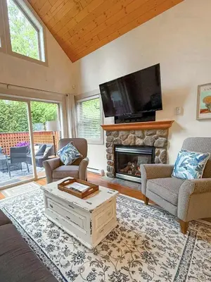 a living room with a fireplace and a flat screen tv at Oceanside Resort 3 BED 2 BATH with Indoor Pool and Hot Tub in Parksville