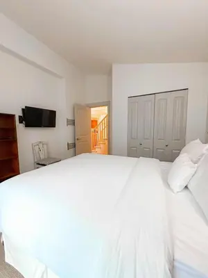 a large white bed in a bedroom with a television at Oceanside Resort 3 BED 2 BATH with Indoor Pool and Hot Tub in Parksville