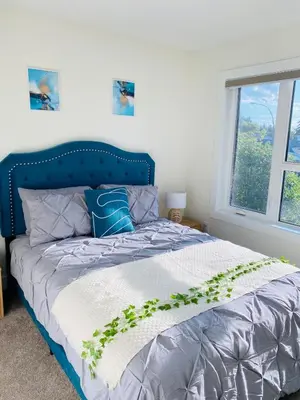 a bedroom with a blue bed with a plant on it at NEW Luxury Family Friendly Entire House Near Downtown WEM, 3 Bedrooms in Edmonton