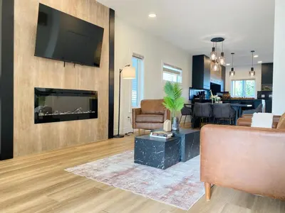a living room with a fireplace and a tv on a wall at NEW Luxury Family Friendly Entire House Near Downtown WEM, 3 Bedrooms in Edmonton