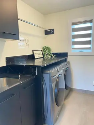 a laundry room with a sink and a washing machine at NEW Luxury Family Friendly Entire House Near Downtown WEM, 3 Bedrooms in Edmonton