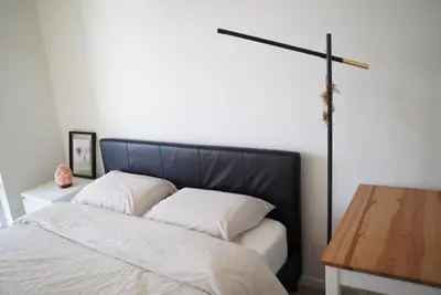 a bed with a black headboard and a wooden table at Cozy Richmond Center Downtown 2B & 2B Apartment in Richmond