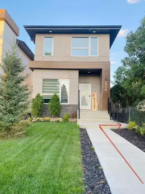 a house with a green lawn in front of it at Modern Cozy Entire Guest Suite in Central Edmonton in Edmonton