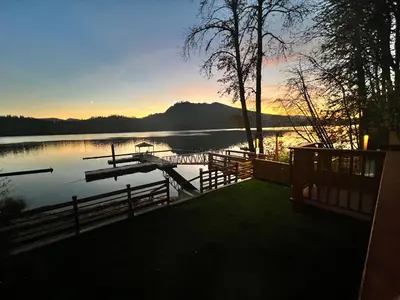 a view of a dock on a lake at sunset at Mile 77 Cottages in Youbou