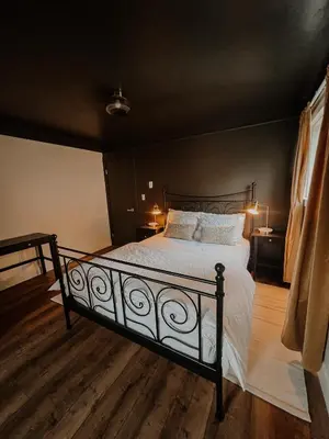 a bedroom with a bed with white sheets and pillows at Wilder Lodge in Fairmont Hot Springs