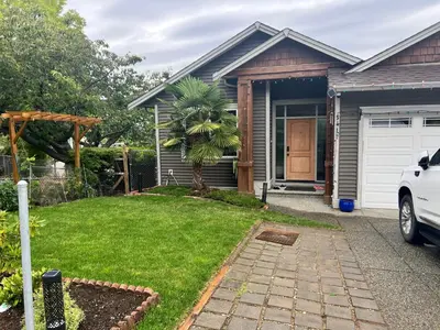 a house with a palm tree in the yard at Tide and Rose Garden in Nanaimo