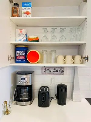a kitchen counter with a coffee pot and glasses on shelves at The Downtown Oasis - A Spacious Family Friendly 3 Bedroom House Close to Everything in Edmonton