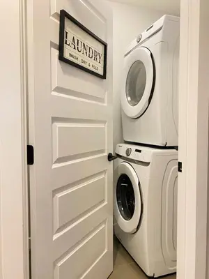 a laundry room with a washer and dryer next to a door at The Downtown Oasis - A Spacious Family Friendly 3 Bedroom House Close to Everything in Edmonton