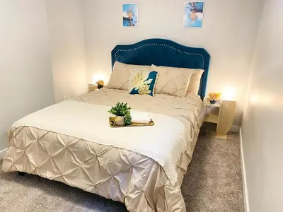 a bedroom with a large bed with a blue headboard at The Private Central Edmonton Suite - Comfortable & Fully-Equipped Basement Suite in Edmonton