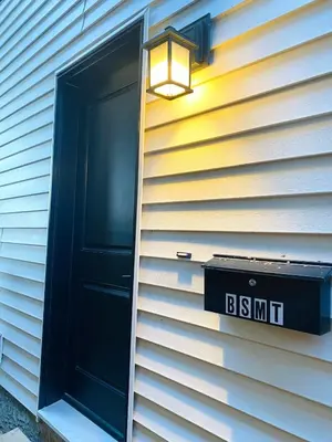 a house with a black door and a light on it at The Private Central Edmonton Suite - Comfortable & Fully-Equipped Basement Suite in Edmonton