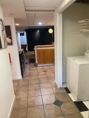 a hallway of a kitchen with a tiled floor at Your Home Away From Home in Abbotsford