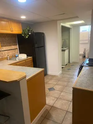 a kitchen with a black refrigerator and a tile floor at Your Home Away From Home in Abbotsford