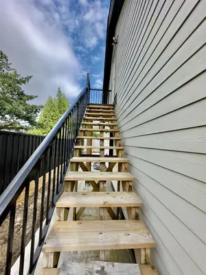 a set of wooden stairs leading up to a building at One-Bedroom Suite in Gibsons in Gibsons