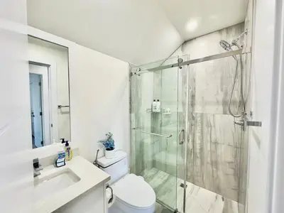 a bathroom with a toilet and a glass shower at One-Bedroom Suite in Gibsons in Gibsons