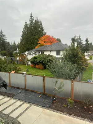 a white fence in front of a house at One-Bedroom Suite in Gibsons in Gibsons