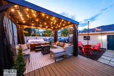 a patio with lights and furniture on a deck at Nordic Spa Retreat - Hot Tub - King Bed - Firepit - BBQ in Edmonton