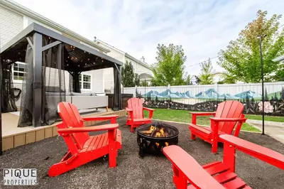 a patio with red chairs and a fire pit at Nordic Spa Retreat - Hot Tub - King Bed - Firepit - BBQ in Edmonton