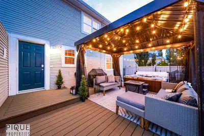 a patio with lights and a couch on a deck at Nordic Spa Retreat - Hot Tub - King Bed - Firepit - BBQ in Edmonton