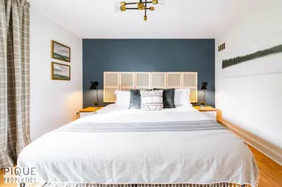 a bedroom with a large white bed with blue walls at Nordic Spa Retreat - Hot Tub - King Bed - Firepit - BBQ in Edmonton
