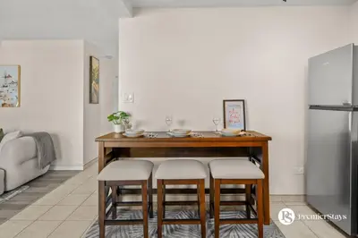a kitchen with a table with chairs and a refrigerator at Downtown 17th Ave Lifestyle with Secure Parking and AC in Calgary