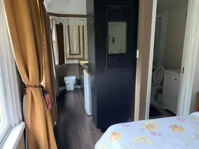 a bedroom with a bed and a door with a mirror at Quiet Backyard Cabin in North Vancouver