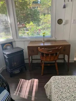 a desk and a chair in a room with a window at Quiet Backyard Cabin in North Vancouver