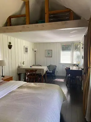 a bedroom with a bed and a dining room with a table at Quiet Backyard Cabin in North Vancouver