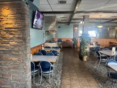 a dining room with tables and chairs and a brick wall at Big Horn motor Inn in Grande Cache