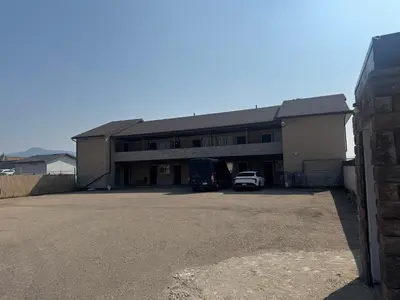 a building with a car parked in a parking lot at Big Horn motor Inn in Grande Cache