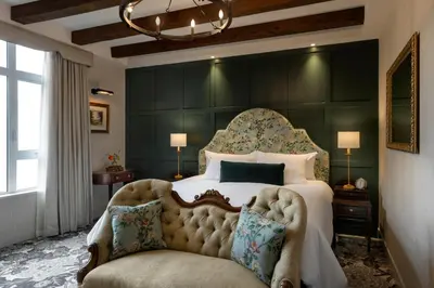 a bedroom with a large bed and a chair at Rosemead House in Victoria