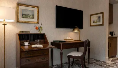 a hotel room with a desk and a television on the wall at Rosemead House in Victoria