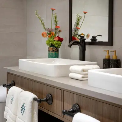 a bathroom with two sinks and a vase with flowers at Rosemead House in Victoria