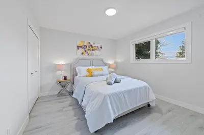 a white bedroom with a bed and a window at Bungalow Southgate University WEM Rogers Place Saville & Snow Resort in Edmonton
