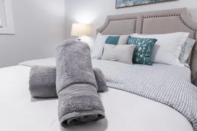 a bed with a blanket laying on top of it at Bungalow Southgate University WEM Rogers Place Saville & Snow Resort in Edmonton