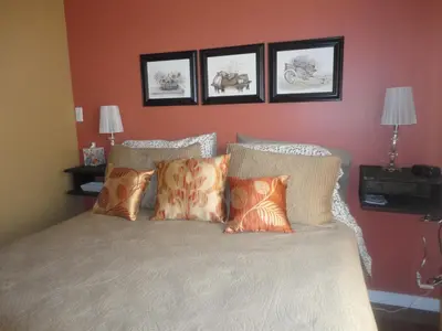 a bedroom with a bed with four pictures on the wall at Vintage Merlot Bed and Breakfast in Oliver