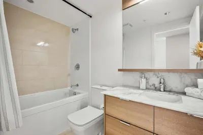 a bathroom with a sink and a toilet and a tub at Riverside Retreat - FREE Banff Pass, Gym, Parking! in Calgary