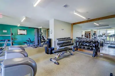 a gym with rows of treadmills and exercise machines at Riverside Retreat - FREE Banff Pass, Gym, Parking! in Calgary