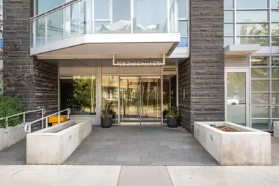 an entrance to a building with a glass door at Riverside Retreat - FREE Banff Pass, Gym, Parking! in Calgary