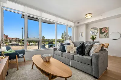 a living room with a couch and a table at Riverside Retreat - FREE Banff Pass, Gym, Parking! in Calgary