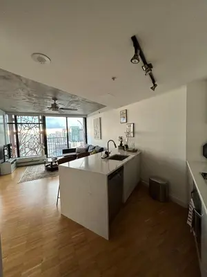 a kitchen with a sink and a living room at Cozy Gastown condo with a view! in Vancouver