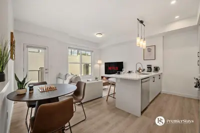 a kitchen and living room with a table and a dining room at Executive Suite with King Bed Garage AC Free Banff Pass 65 Inch TV in Calgary