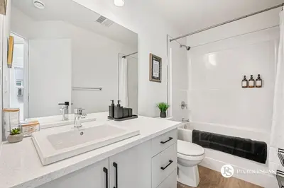 a white bathroom with a sink and a toilet at Executive Suite with King Bed Garage AC Free Banff Pass 65 Inch TV in Calgary