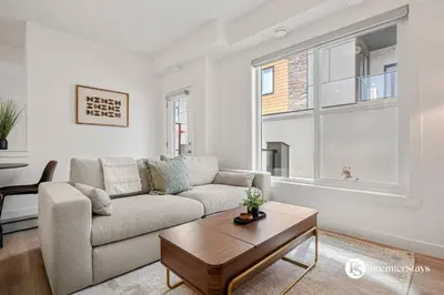 a living room with a couch and a table at Executive Suite with King Bed Garage AC Free Banff Pass 65 Inch TV in Calgary