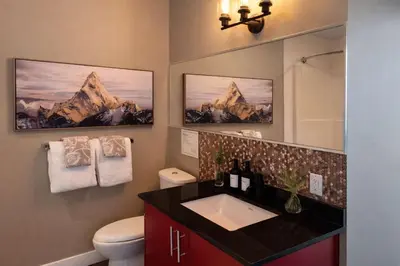 a bathroom with a sink and a toilet and a mirror at Summit Mountain & Skyline Views Beltline in Calgary
