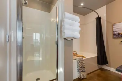 a bathroom with a shower and some towels at Summit Mountain & Skyline Views Beltline in Calgary