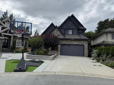 a house with a basketball hoop in the driveway at Private two bedroom basement suite Sleeps six people in Surrey